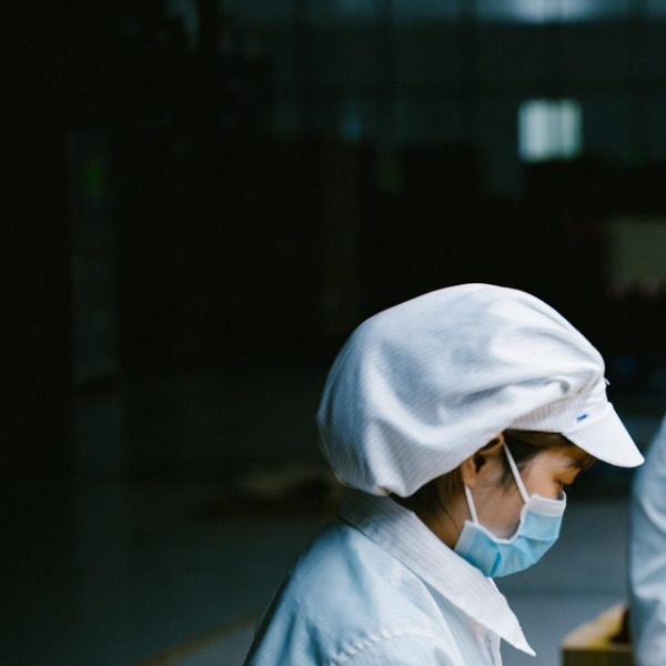 CleanCare operative in cap and mask at work