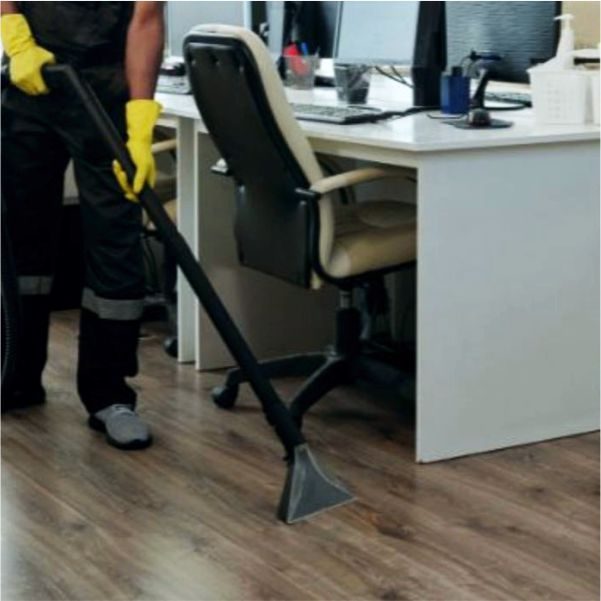 Cleaner vacuuming an office floor